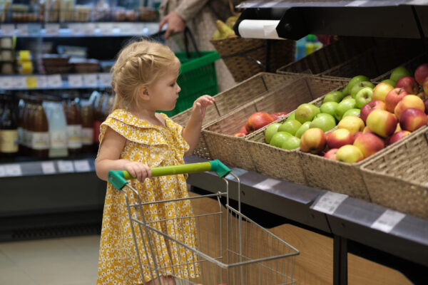 taking kids out in public, girl pushing own grocery chart in store