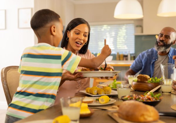 multigenerational family enjoying meal together at home sharing food and smiling around table dinner happiness bonding togetherness - SKIDamarink KIDs
