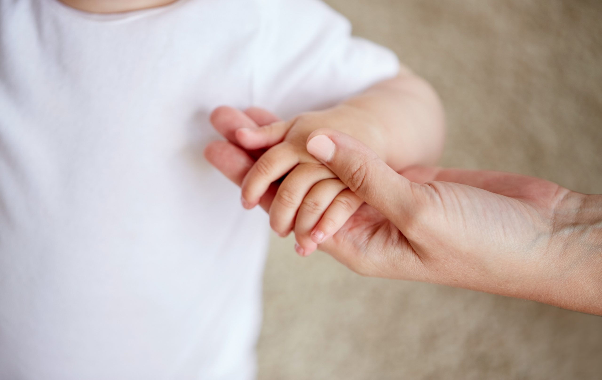 close up of little baby and mother hands - SKIDamarink KIDs