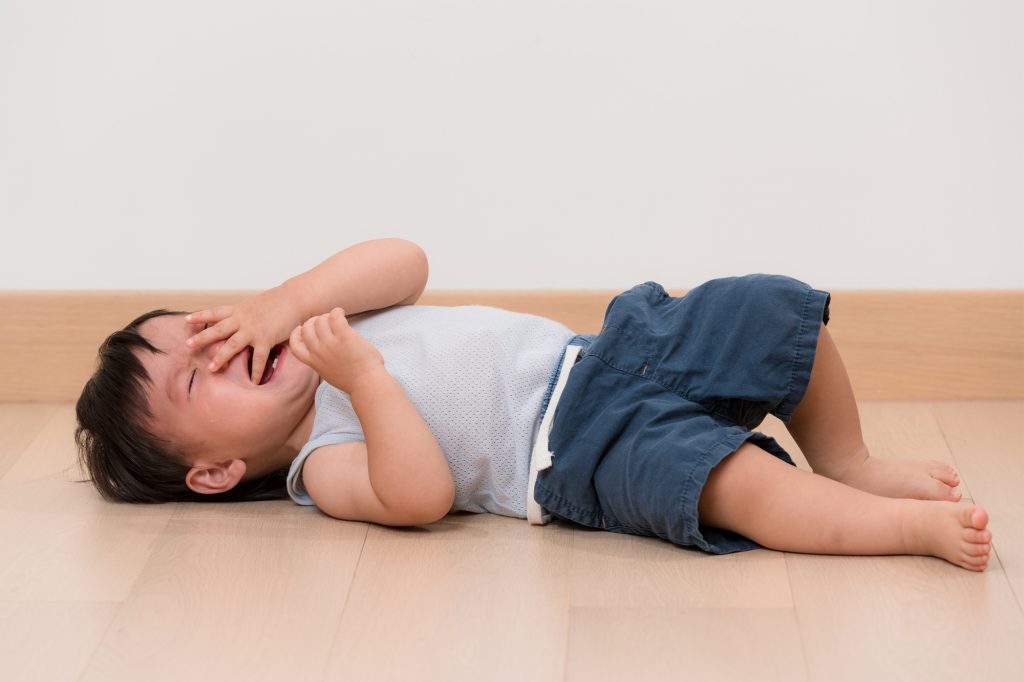 Asian little boy cry and lying on floor