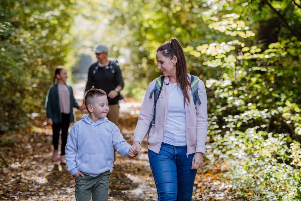 Happy family with kids walking in forest - SKIDamarink KIDs Happy family with kids walking in forest.
