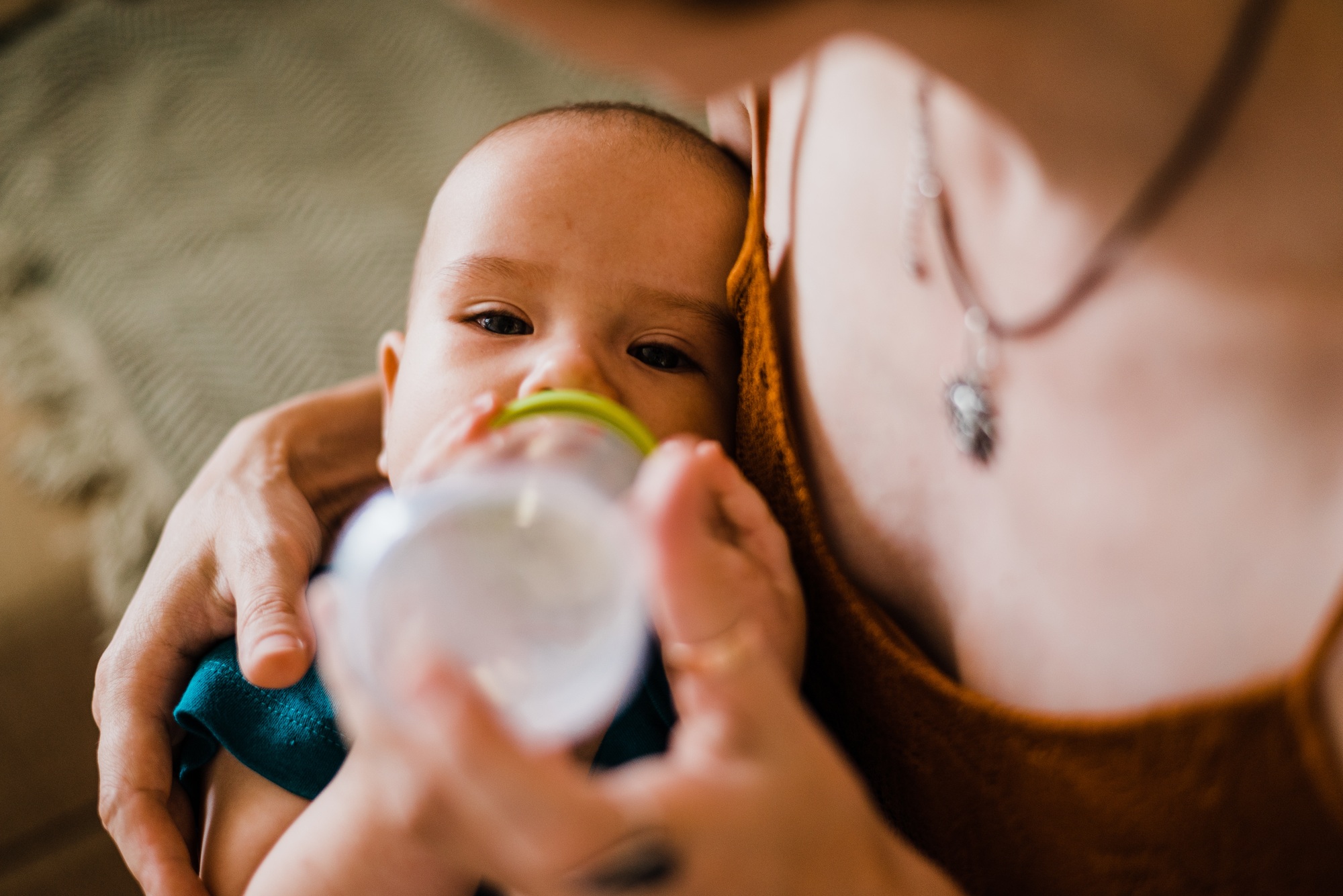 Mom feeds her baby with bottle infant child indoors at home Candid family - SKIDamarink KIDs Mom feeds her baby with bottle infant child indoors at home. Candid family