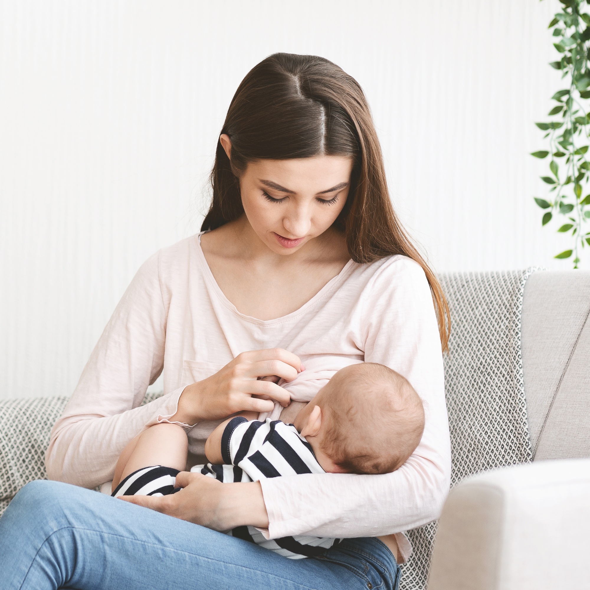 Young mother feeding her newborn child with breast milk - SKIDamarink KIDs Young mother feeding her newborn child with breast milk