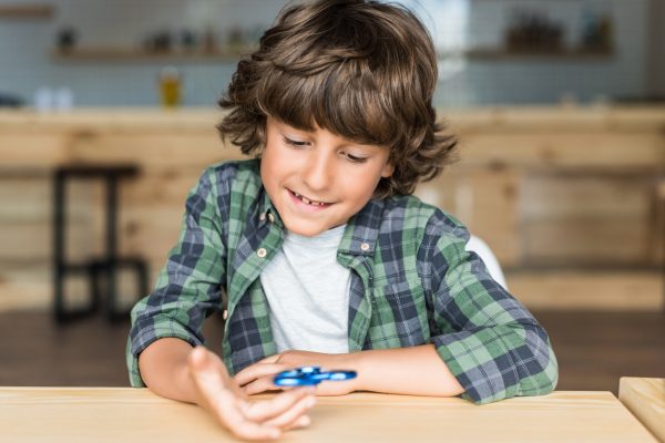 cute smiling boy with fidget spinner in hand - SKIDamarink KIDs cute smiling boy with fidget spinner in hand