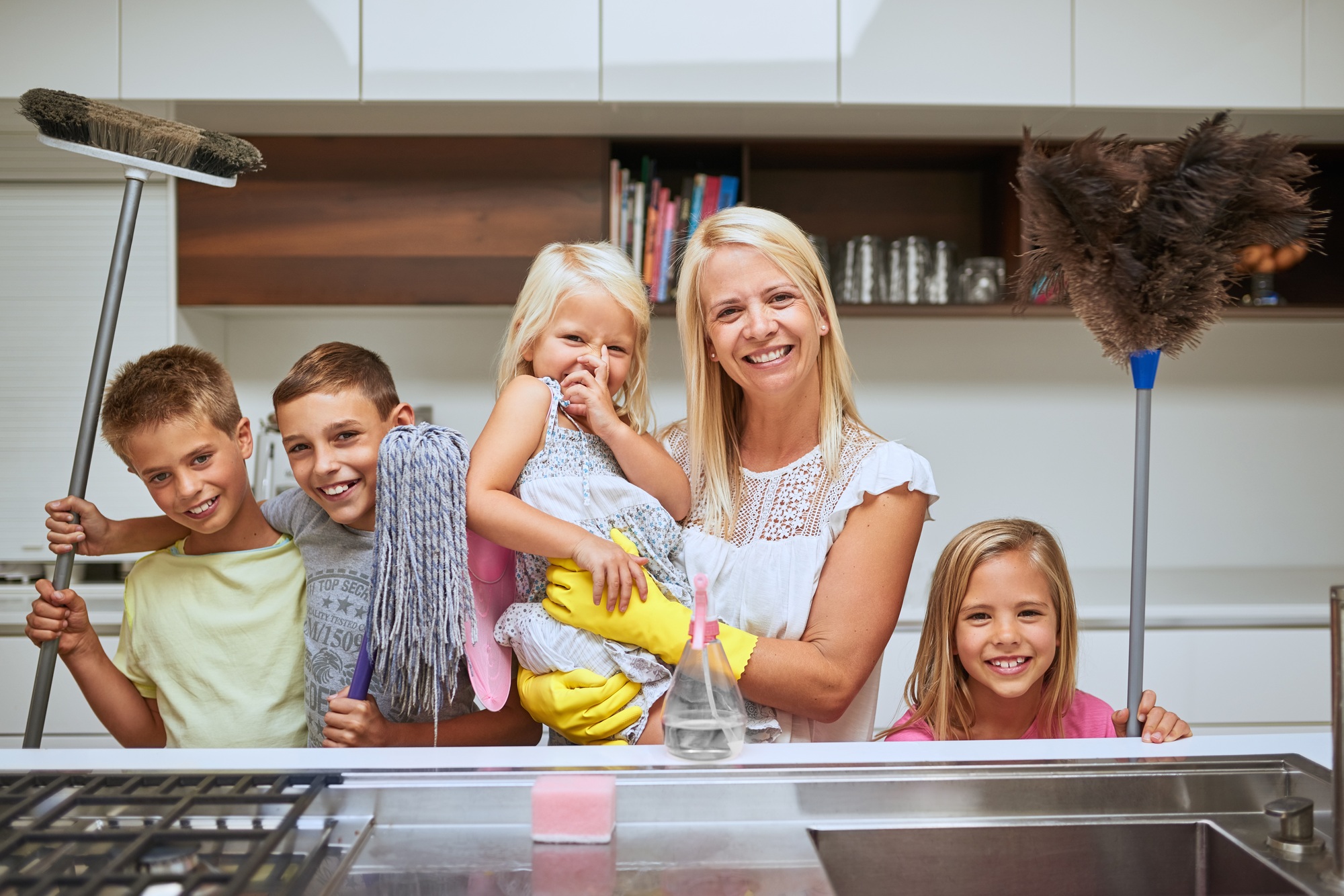 Portrait of a mother and her kids doing chores together at home
