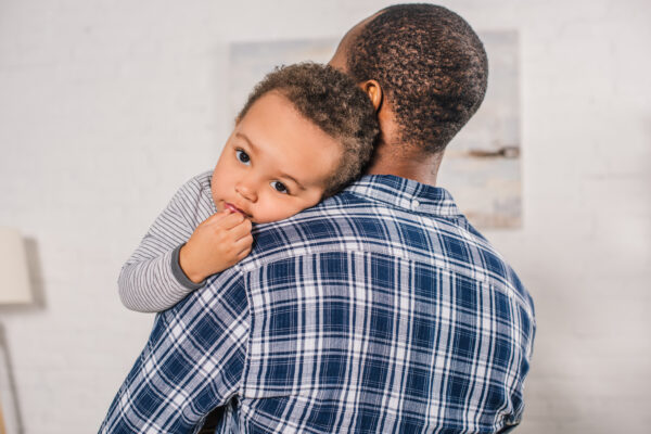young african american father carrying adorable little son at home - SKIDamarink KIDs father holds toddler, child self regulation through co-regulation