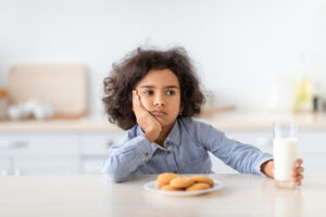 Portrait Of Sad Little Afro Girl Holding Glass Of Milk - SKIDamarink KIDs child refusing foods, child food sensitivities and behavior